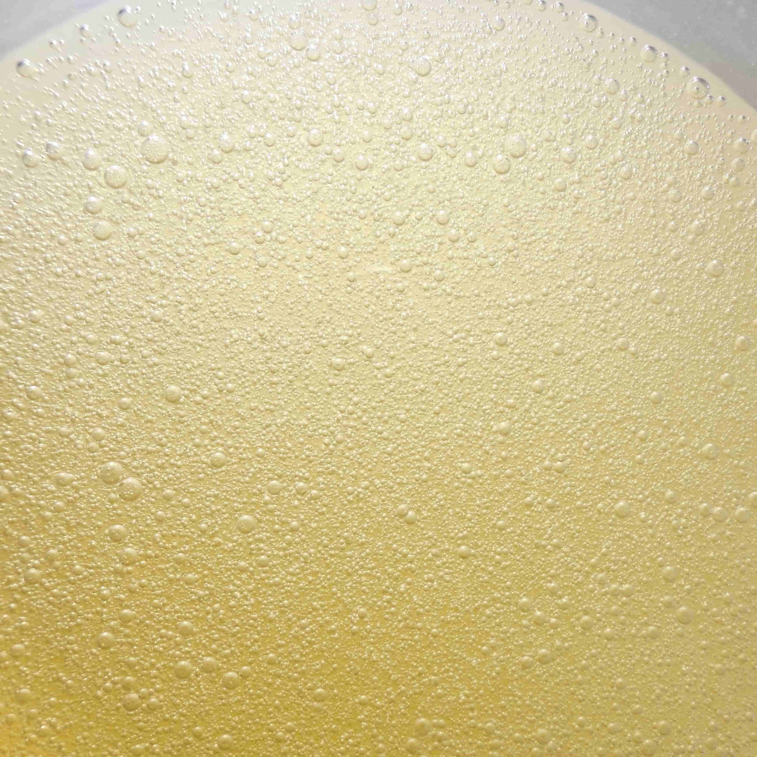 Bright yellow clear bubbles oil gel with light going through it texture photo skincare oil 