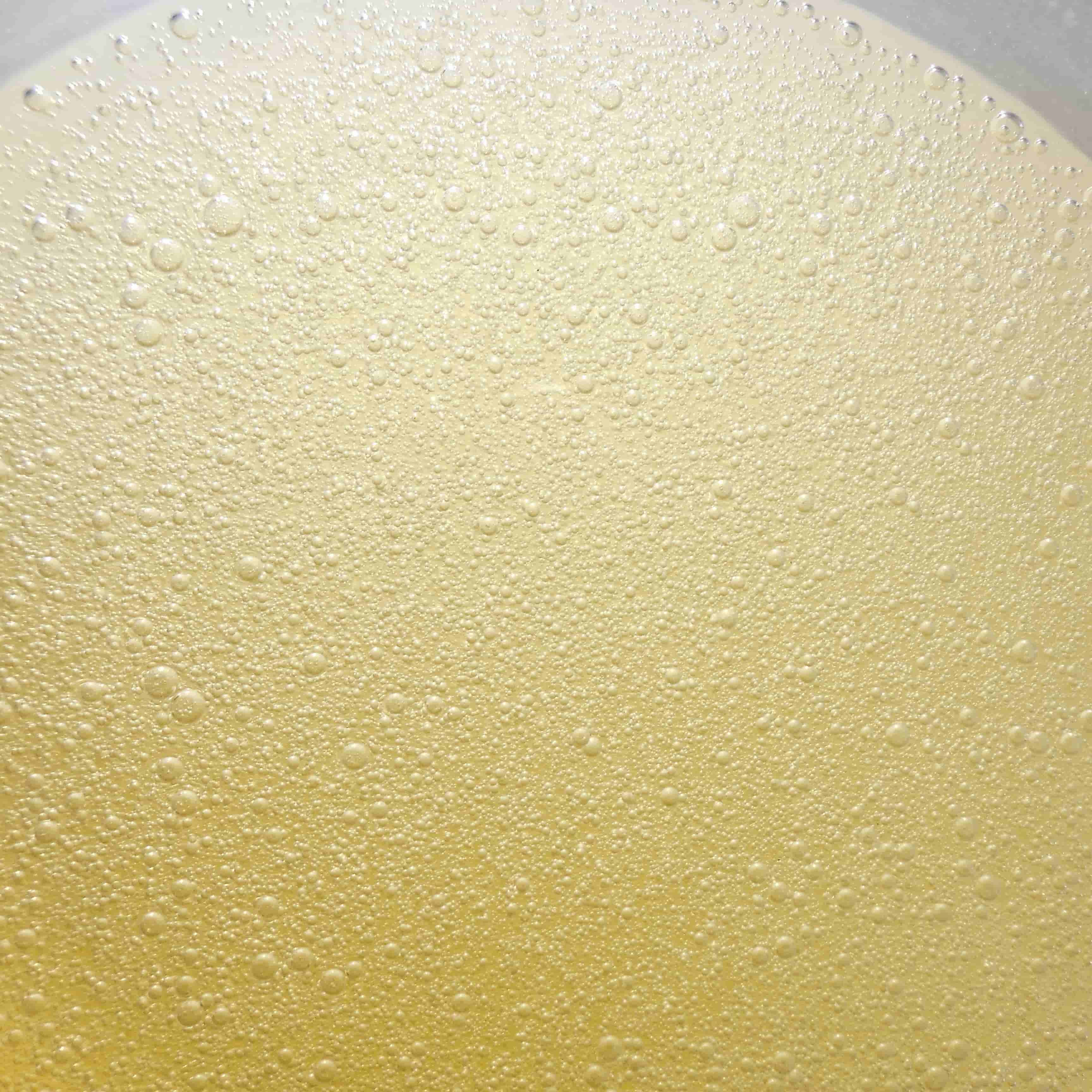 Bright yellow clear bubbles oil gel with light going through it texture photo skincare oil 