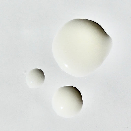 Close up droplets of the off-white Vitamin C Brightening Serum