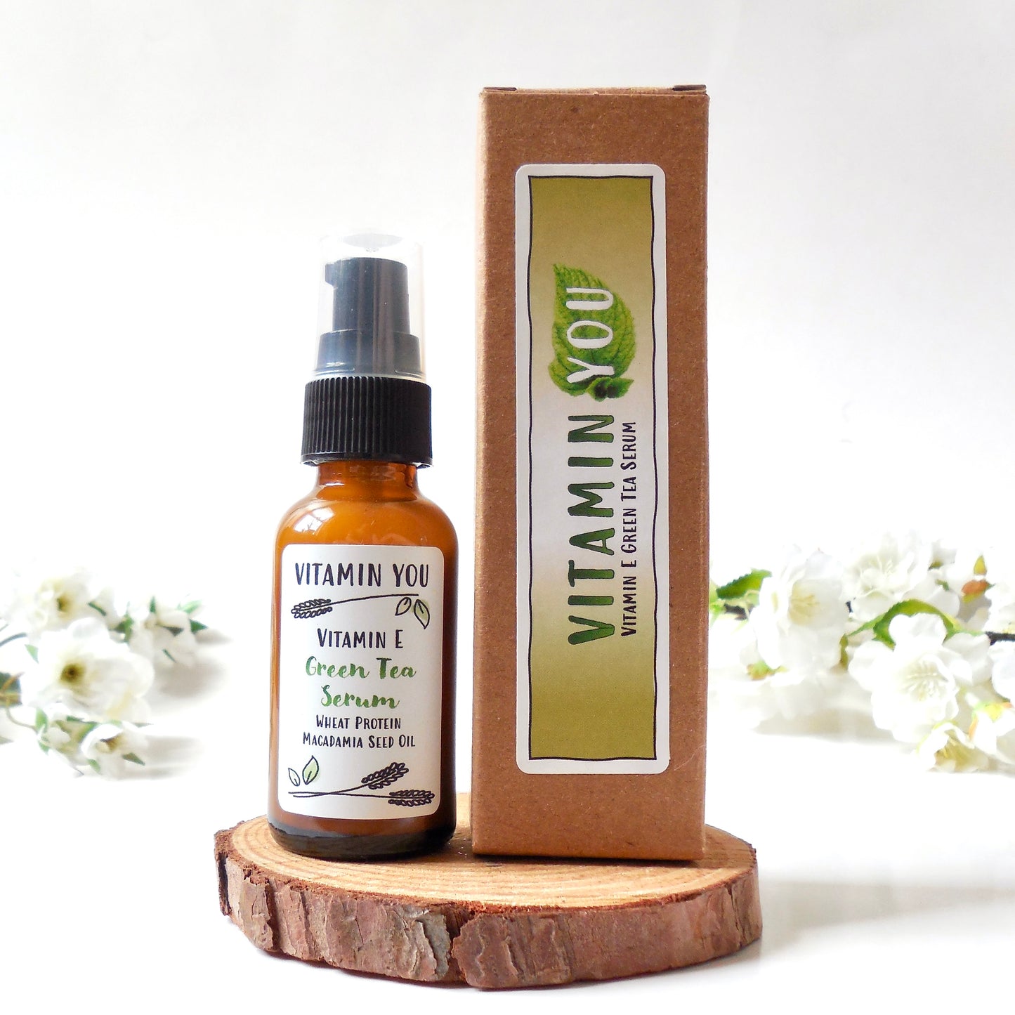 Bottle and box of the Vitamin You Vitamin E Green Tea Serum with a tea leaf green theme
