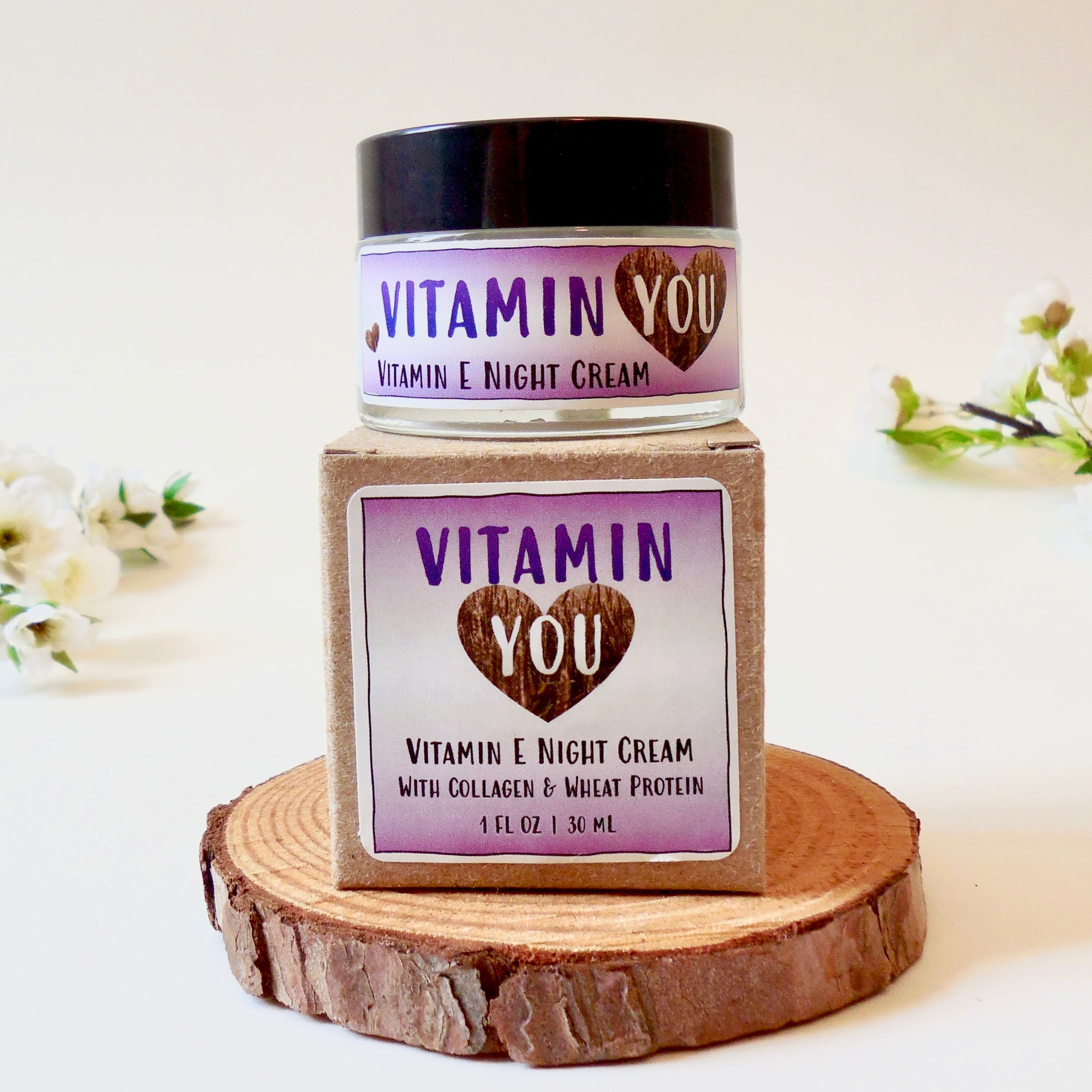 Vitamin E night cream with 'Vitamin You' purple branding on a wooden stand.